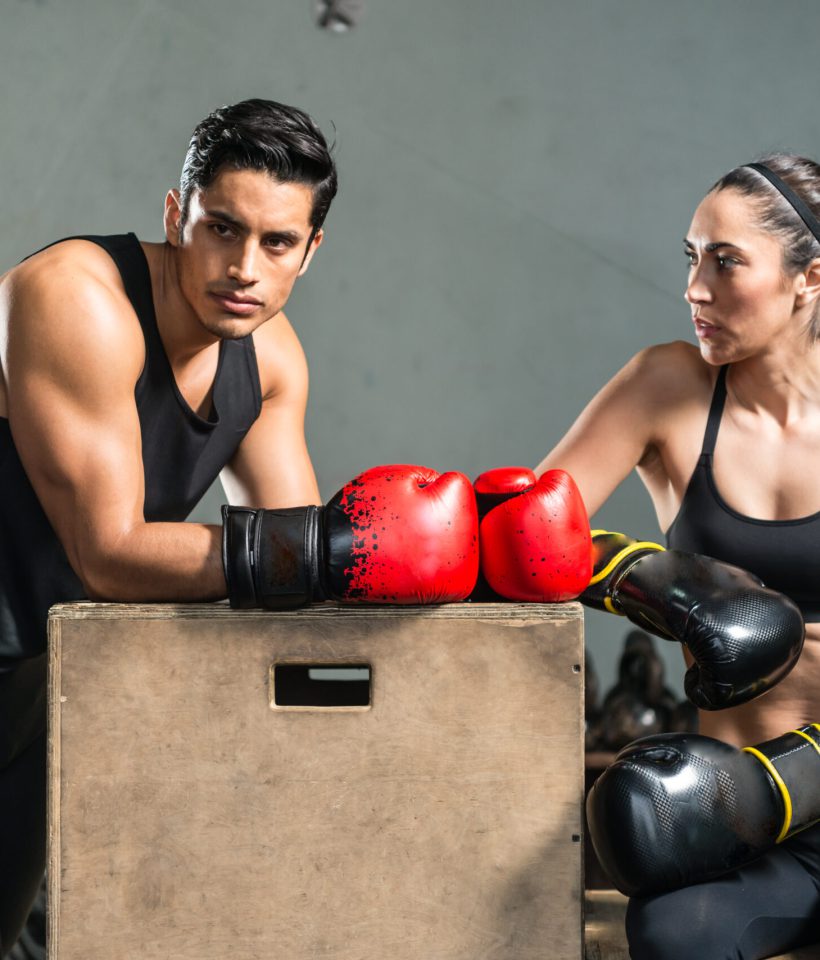 A hispanic couple with boxing gloves on resting.